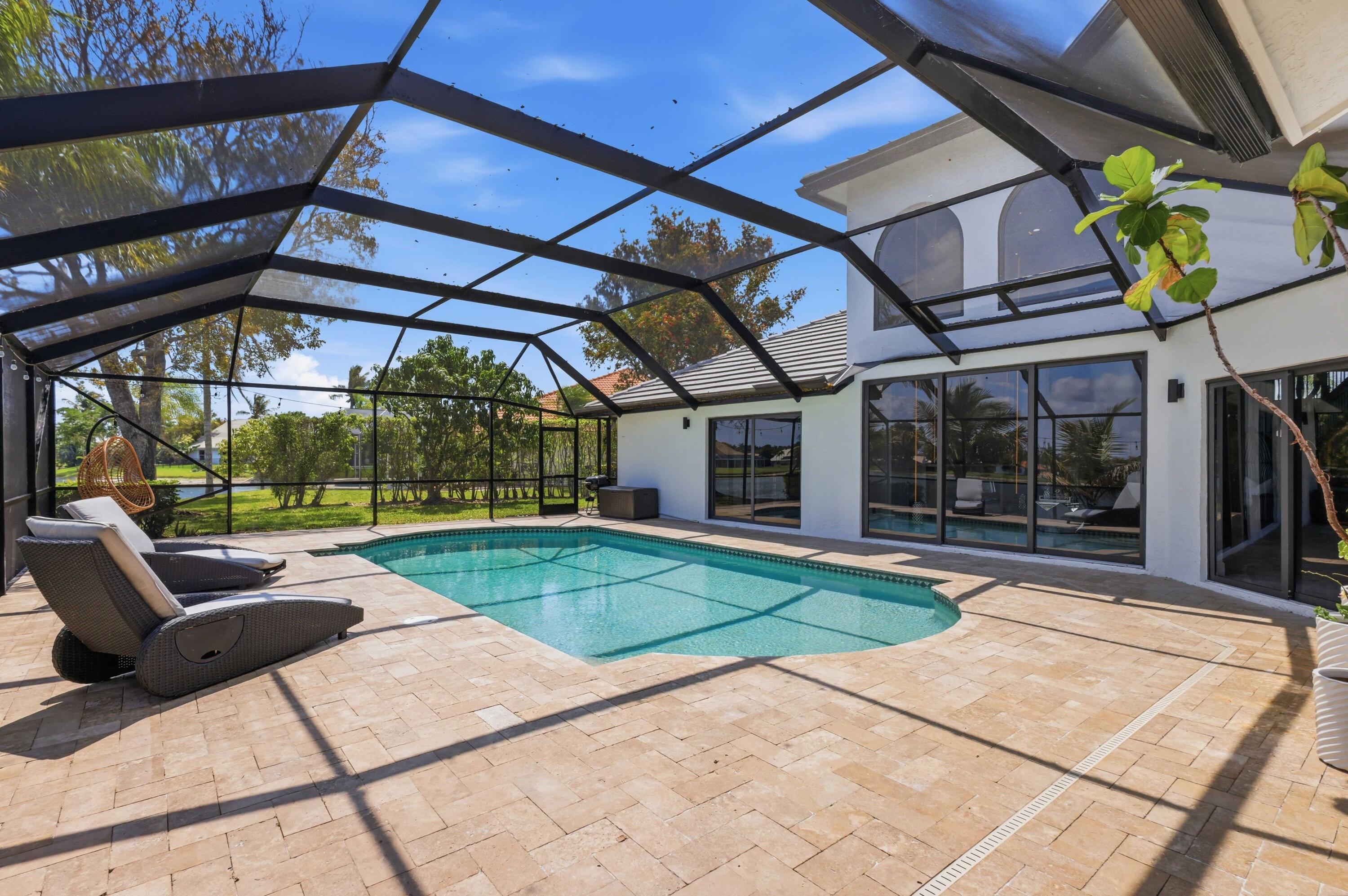 22257 Vista Lago Drive Boca Raton, FL 33428 - Photo 52 of 82 a view of a patio with a table and chairs under an umbrella