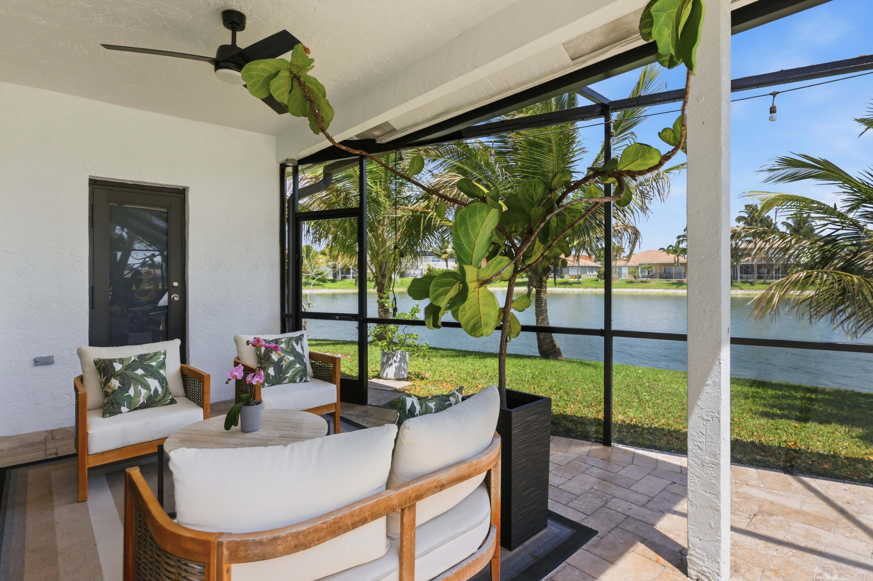 22257 Vista Lago Drive Boca Raton, FL 33428 - Photo 60 of 82 a living room with large windows and a table