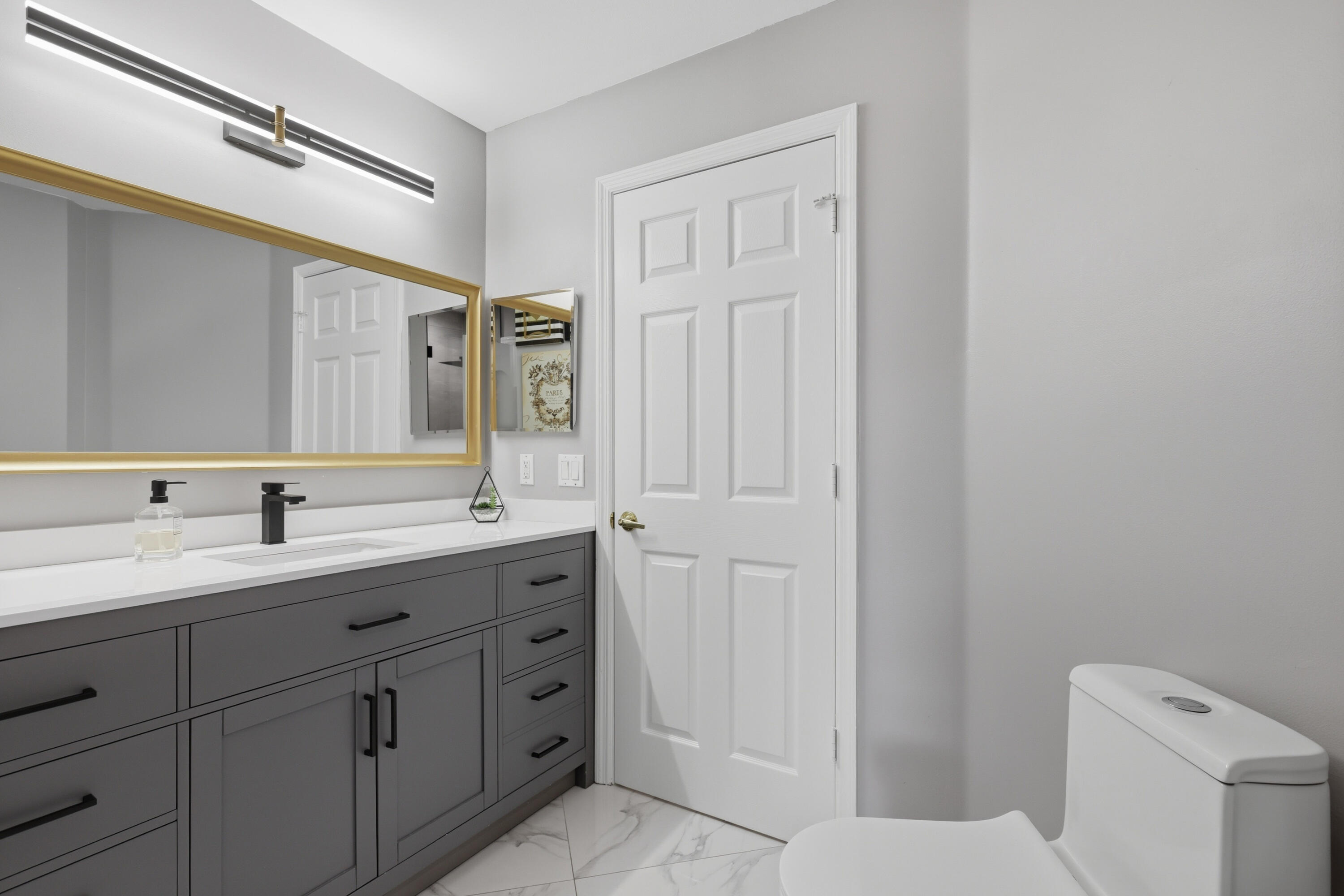 22257 Vista Lago Drive Boca Raton, FL 33428 - Photo 64 of 82 a bathroom with a granite countertop sink a toilet and a mirror