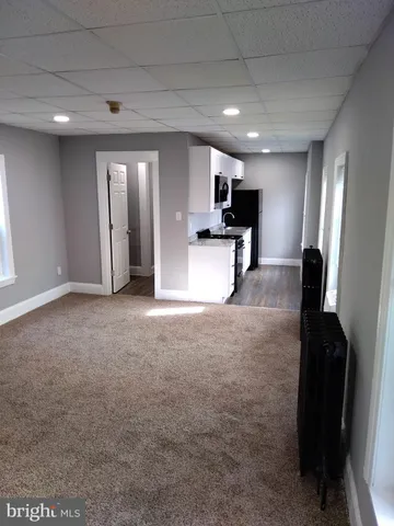 a view of a big room with entryway wooden floor and windows