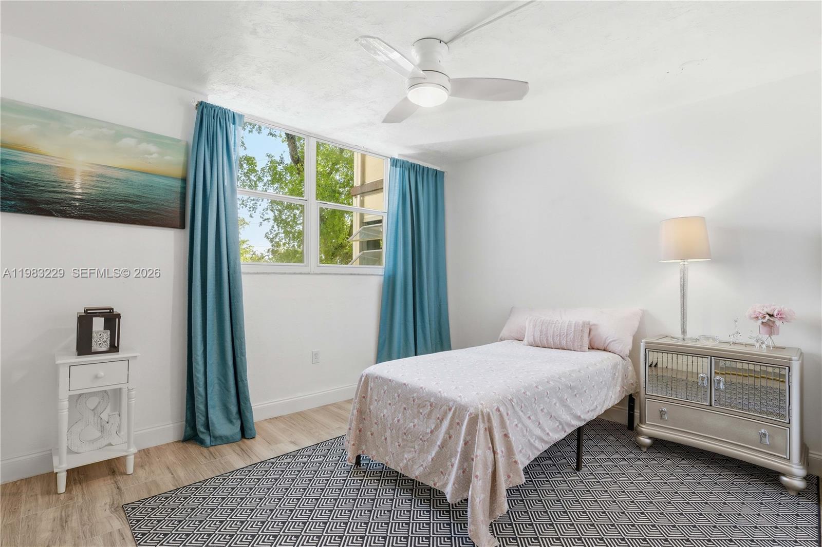 7100 Northwest 17th Street, Unit 210 Plantation, FL 33313 - Photo 8 of 15 a bedroom with a bed a dresser and wooden floor