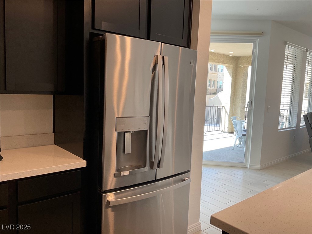 2555 Hampton Road, Unit 4209 Henderson, NV 89052 - Photo 15 of 67 Kitchen with stainless steel refrigerator with ice dispenser, light stone countertops, dark cabinets, and light wood-style flooring