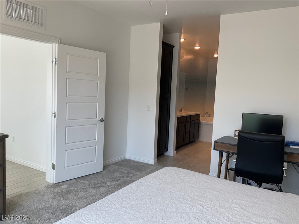 2555 Hampton Road, Unit 4209 Henderson, NV 89052 - Photo 41 of 67 Bedroom featuring light colored carpet, connected bathroom, a desk, and light wood-style flooring