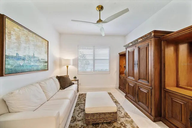 a view of a hallway with stainless steel appliances wooden floor and living room view
