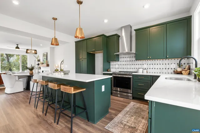 a kitchen with a stove a sink dishwasher a dining table and chairs with wooden floor