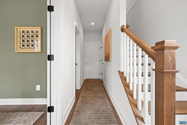 a view of a hallway with wooden floor and staircase