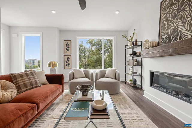a living room with furniture fireplace and a large window