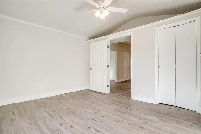 an empty room with wooden floor and closet area
