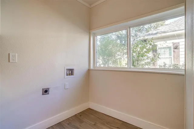 a view of a small space with wooden floor and a window