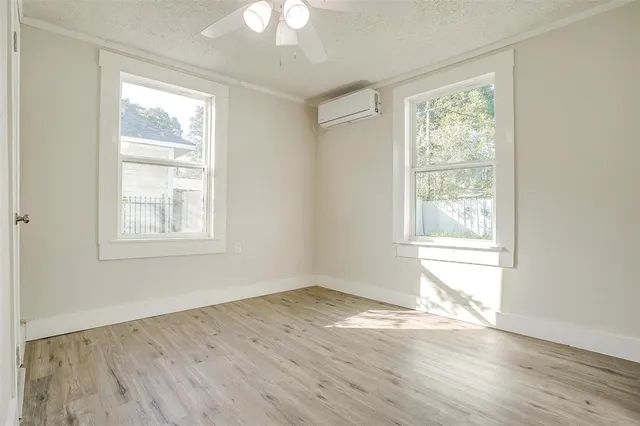 a view of empty room with wooden floor and fan