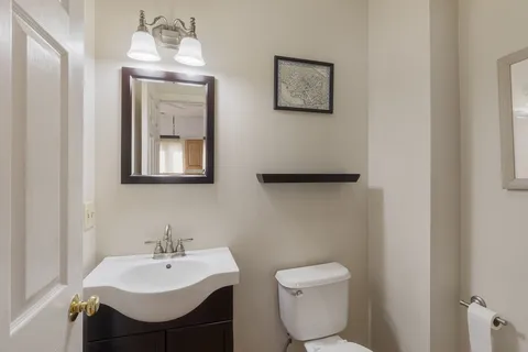 a bathroom with a toilet a sink and mirror