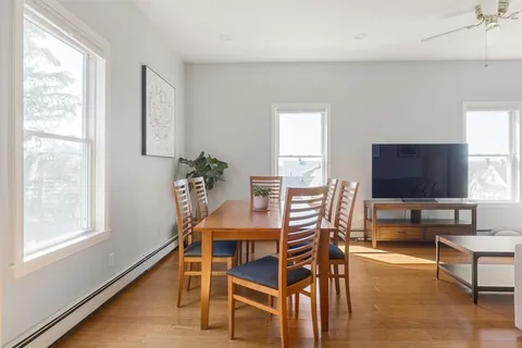 a dining room with furniture and wooden floor