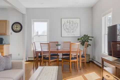 a dining room with furniture and a large window