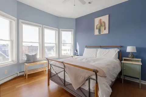 a bedroom with a bed and a couch next to a window