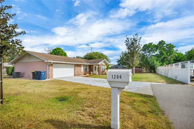 a view of a house with a yard and fence