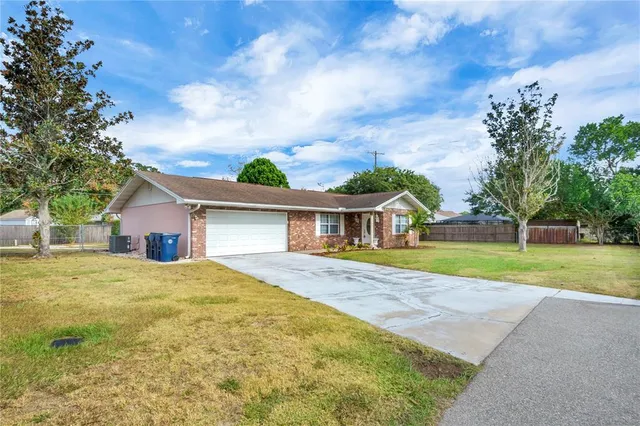 a front view of house with yard and trees in the background