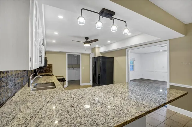a view of a kitchen with a sink and refrigerator
