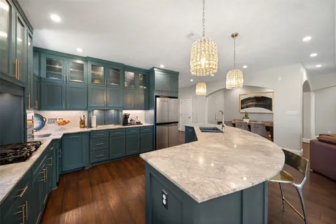 a kitchen with stainless steel appliances granite countertop a sink a stove top oven a counter space and cabinets