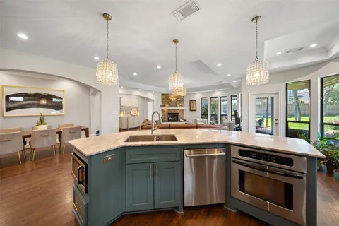 a kitchen with a sink stove and wooden floor