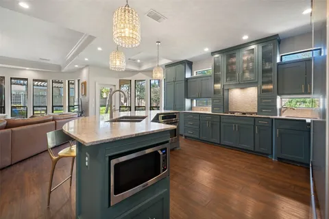 a kitchen with stainless steel appliances granite countertop a sink and a wooden floors