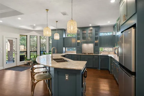 a kitchen with stainless steel appliances granite countertop a sink stove and refrigerator