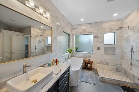 a spacious bathroom with a bathtub shower sink and mirror