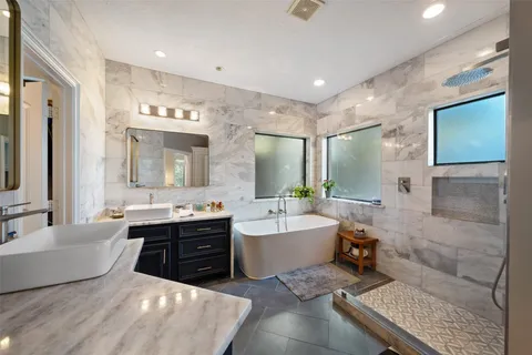 a spacious bathroom with a double vanity sink mirror and bathtub