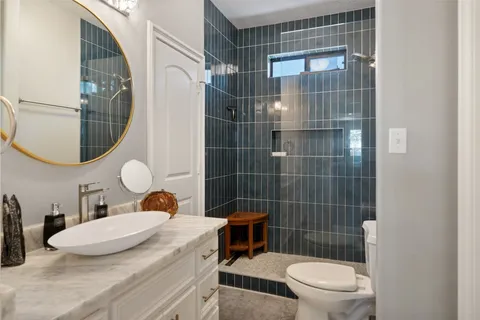 a bathroom with a sink a toilet and shower