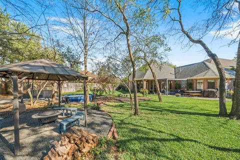 a backyard of a house with barbeque oven table and chairs