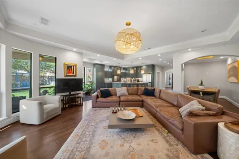 a living room with furniture kitchen view and a large window