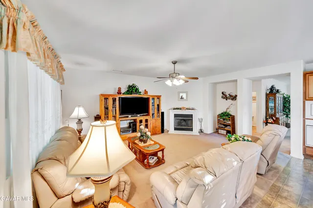 a living room with fireplace furniture and a large window
