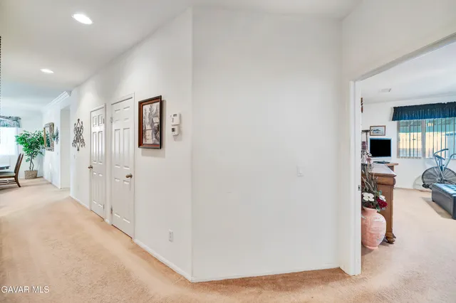 a bedroom with a bed and a flat tv screen on the dresser