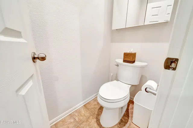 a bathroom with a granite countertop sink a large mirror and a bathtub next to a window