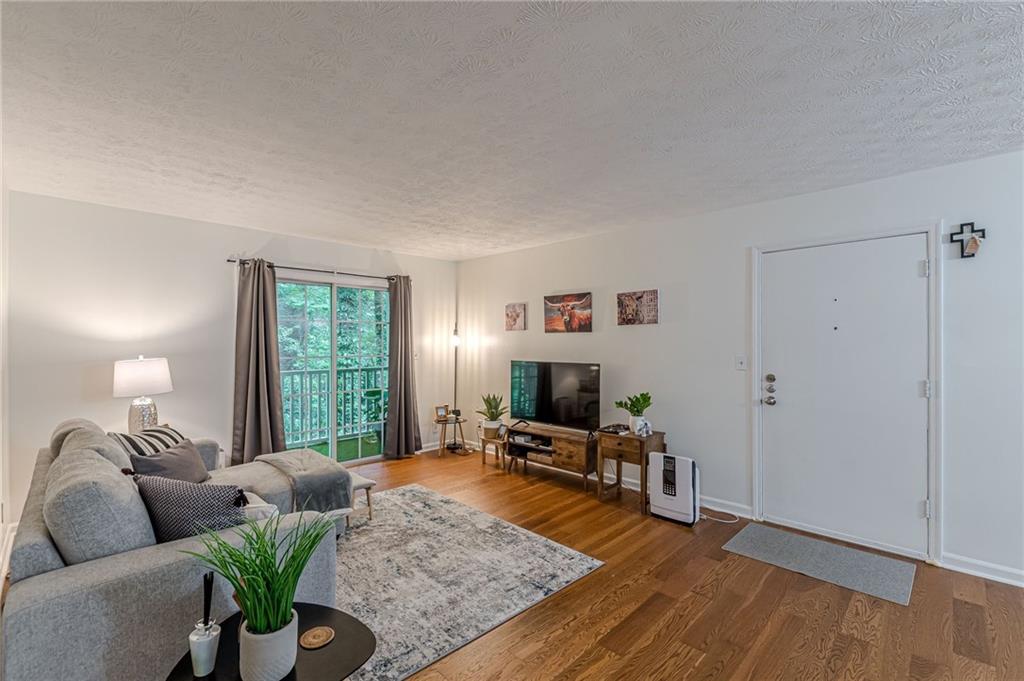3135 Seven Pines, Unit 201 Atlanta, GA 30339 - Photo 1 of 1 a living room with furniture and a wooden floor