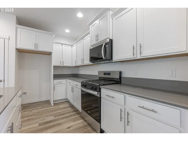 a large kitchen with kitchen island a sink stainless steel appliances and cabinets