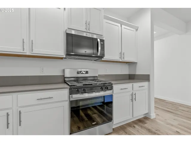 a kitchen with stainless steel appliances granite countertop a sink a stove and a refrigerator