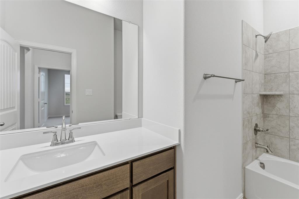 119 Hillview Trail Decatur, TX 76234 - Photo 15 of 30 Bathroom featuring a wood-finish vanity with a white countertop and integrated sink, a large mirror, and a tiled shower-tub combination with a recessed shelf