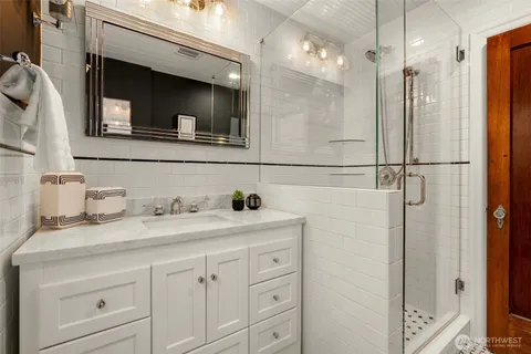a bathroom with a sink a vanity a mirror and shower