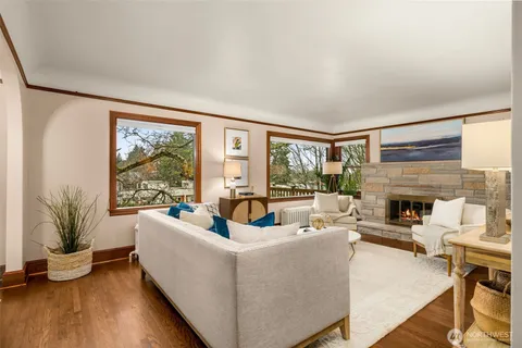 a living room with fireplace furniture and a large window