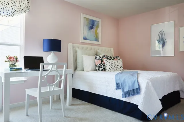 a bedroom with a bed and chair with potted plant on the table
