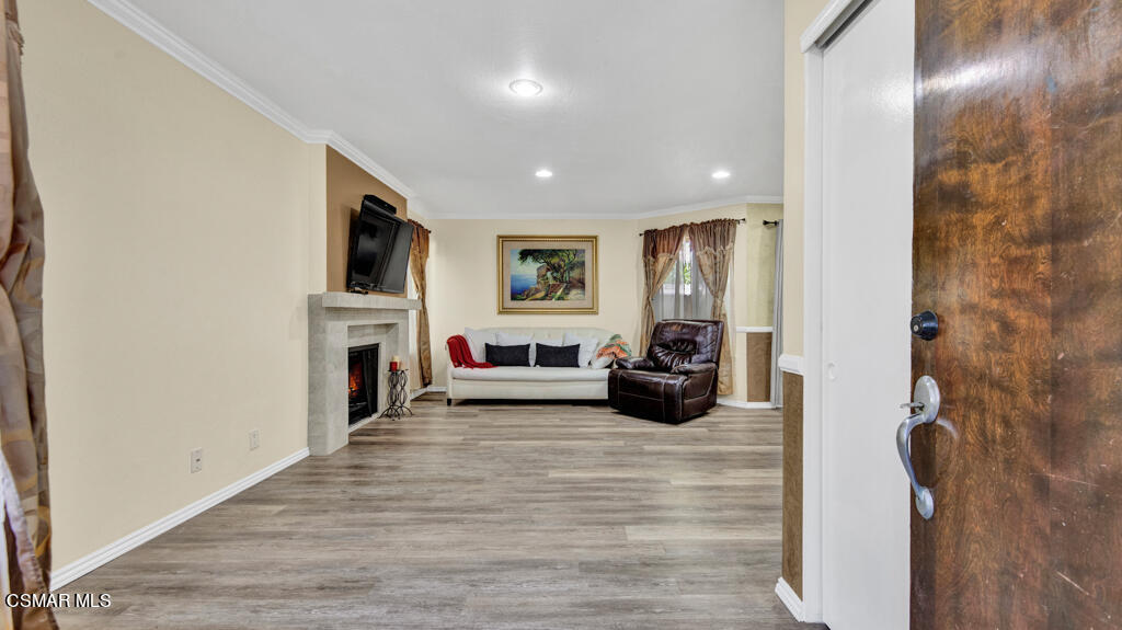 1712 Sinaloa Road, Unit 106 Simi Valley, CA 93065 - Photo 2 of 30 a living room with furniture a fireplace and a flat screen tv