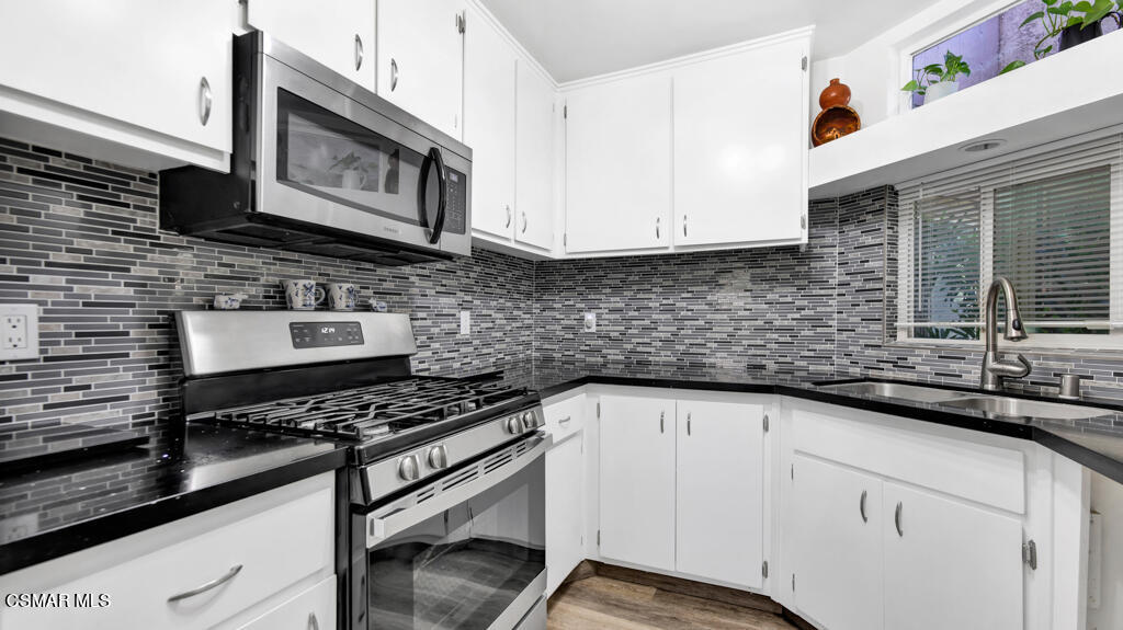 1712 Sinaloa Road, Unit 106 Simi Valley, CA 93065 - Photo 7 of 30 a kitchen with stainless steel appliances granite countertop a sink a stove and cabinets