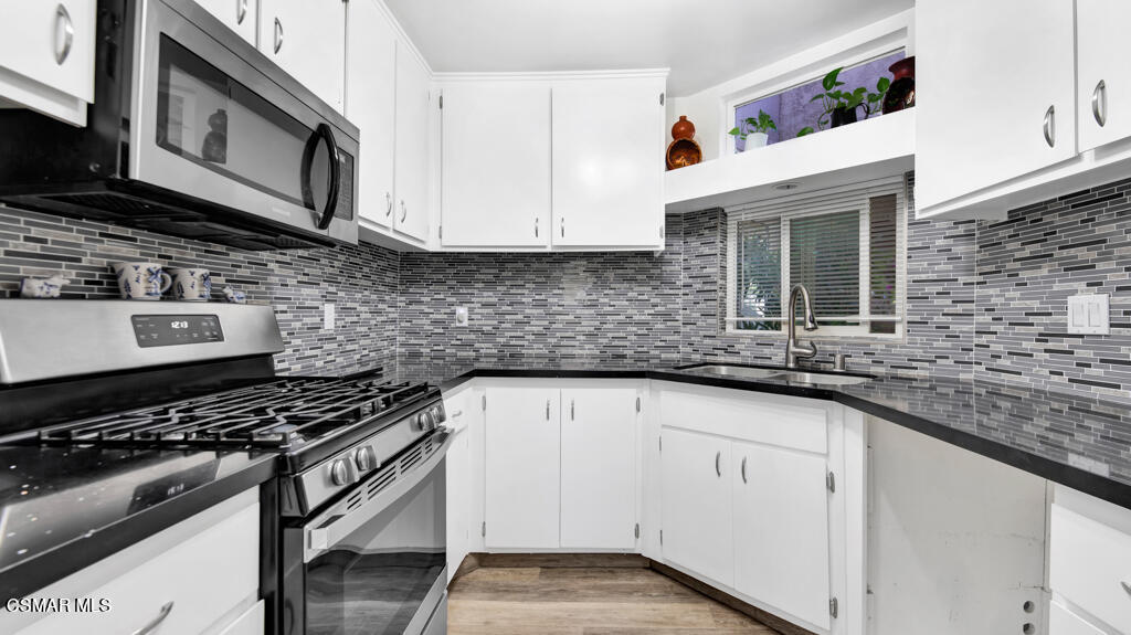 1712 Sinaloa Road, Unit 106 Simi Valley, CA 93065 - Photo 8 of 30 a kitchen with stainless steel appliances granite countertop a sink stove and cabinets