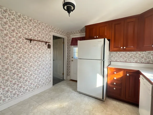 a living room with a stove and a refrigerator