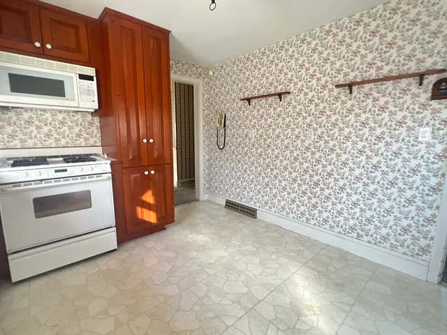 a large kitchen with stainless steel appliances granite countertop a refrigerator and a sink