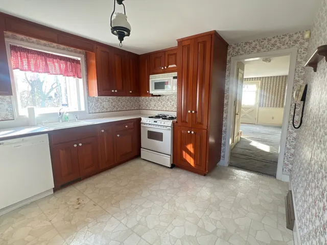 a kitchen with stainless steel appliances granite countertop a refrigerator a sink a stove a microwave and island