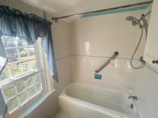 an empty room with windows and ceiling fan