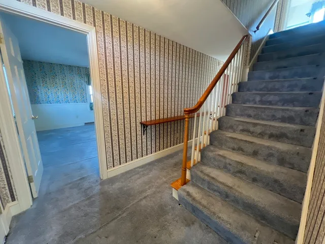 an empty room with windows and fireplace