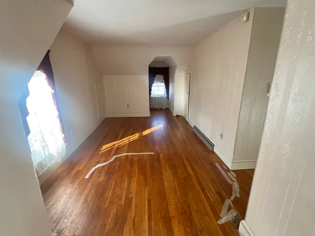 a view of a livingroom with wooden floor and window