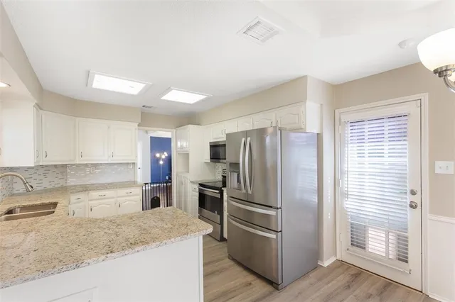 a kitchen with stainless steel appliances granite countertop a refrigerator and a sink